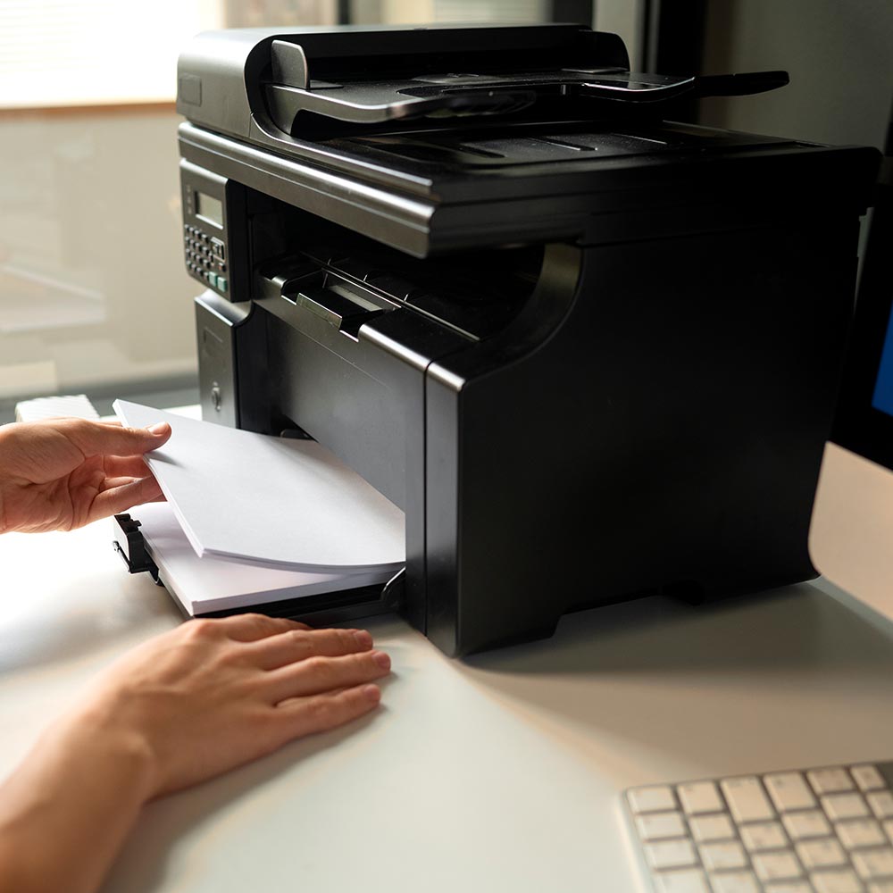 Людина завантажує папір у принтер — послуги друку, копіювання, сканування документів, Київ