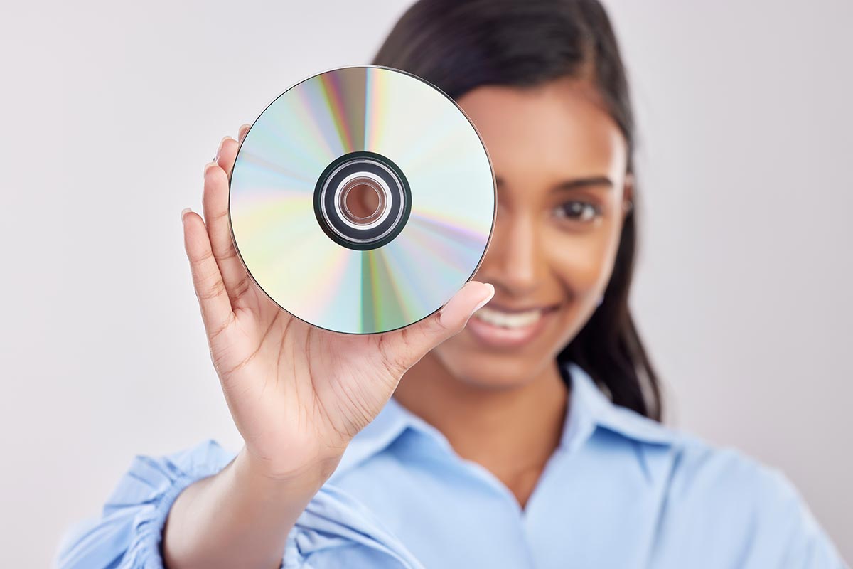Усміхнена жінка тримає чистий DVD-диск в руці — запис фото на диск, Київ