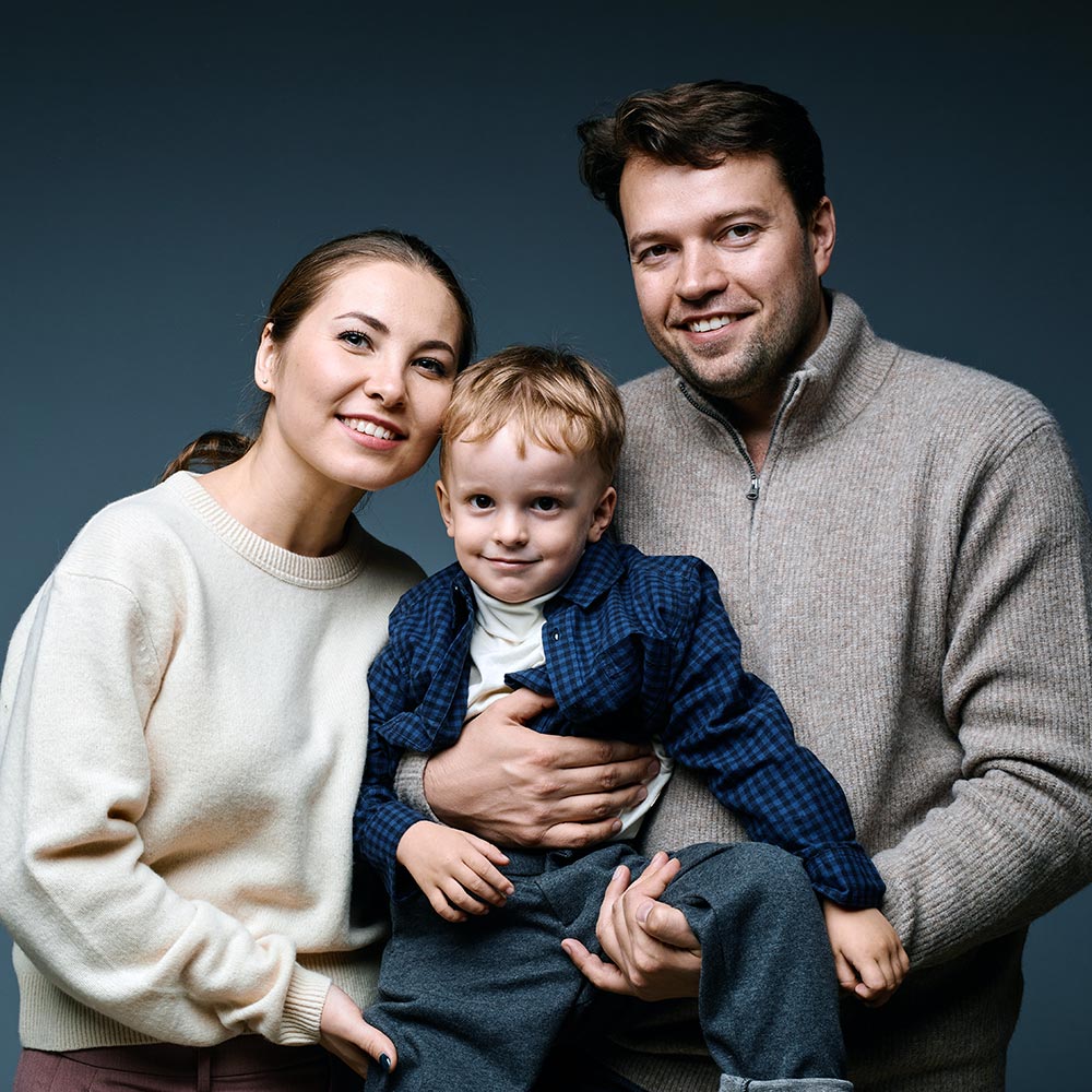 Як підготуватися до сімейної фотосесії: секрети ідеальних знімків від професіоналів 1 Сімейний портрет у студії — мама, тато й син позують на темному фоні, Київ