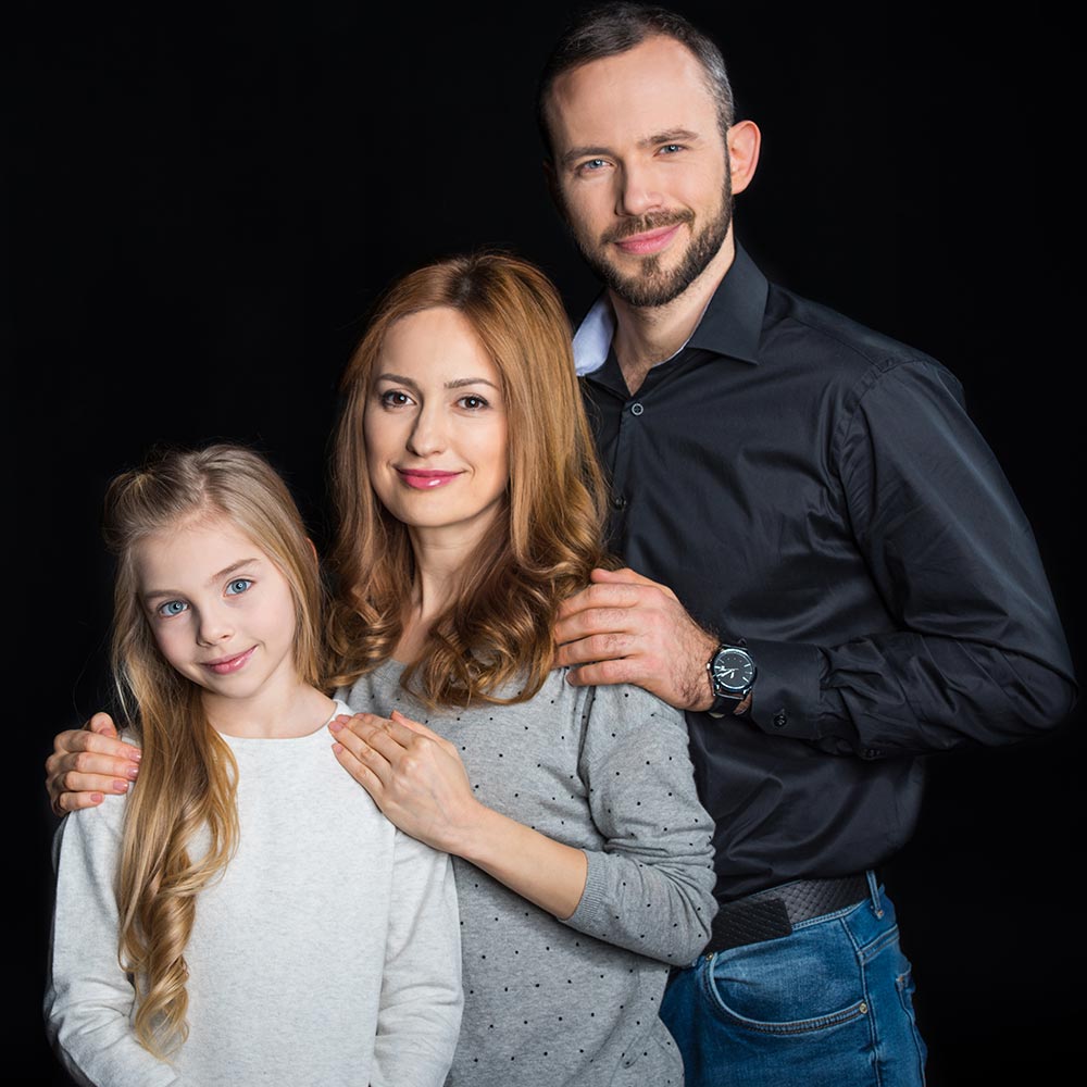 Сімейна фотосесія у студії — щасливі тато, мама й донька на чорному фоні, Київ