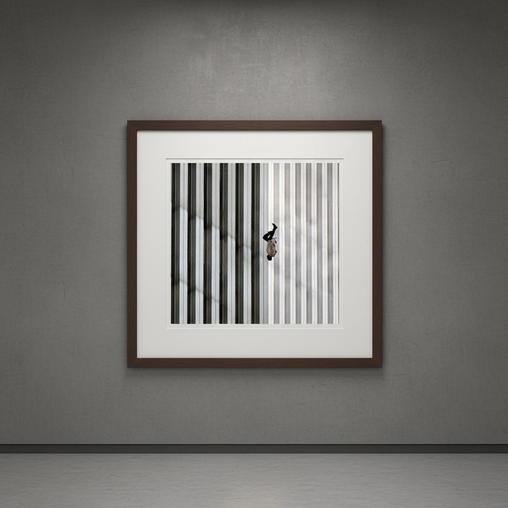 Фотографія "Той, що падає" на фоні вертикальних смуг фасаду Всесвітнього торгового центру